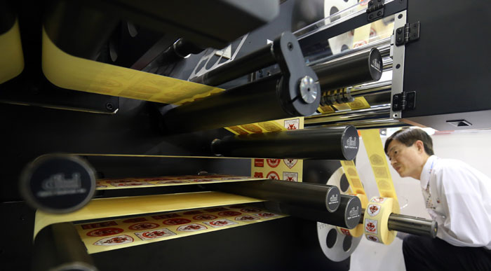 A staff member of an exhibiting company demonstrates how to use a cutting machine to cut and print labels at the Korea Int'l Packaging Exhibition on June 10 at KINTEX in Goyang City, Gyeonggi Province. (photo: Yonhap News)