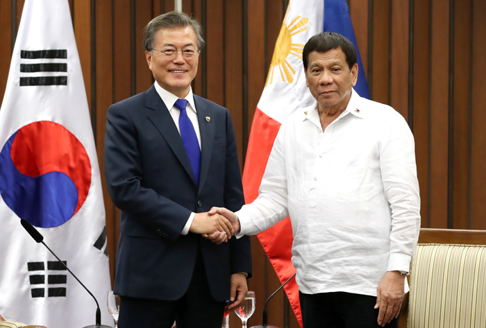 President Moon Jae-in (left) poses for a photo with Philippine President Rodrigo Duterte ahead of a summit at the Philippine International Convention Center in Manila on Nov. 13.
