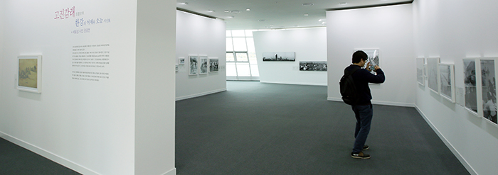 A visitor takes a picture in a photo exhibition underway at Some Solvit, one of the three man-made islands floating on the Hangang River.