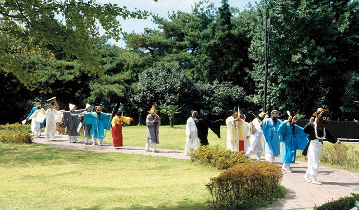 A pre-show parade takes place before a performance of the Tongyeong five-clown mask dance. 