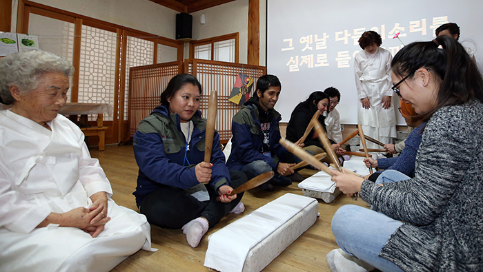 Korea.net honorary reporters try out <i>dadeumijil</i>, a traditional method of smoothing fabric, at the Changpo Traditional Village in Wanju, North Jeolla Province, on Dec. 12.