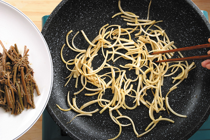 Season the bracken and bellflower with seasoning sauce and stir-fry it over a preheated pan over medium heat.