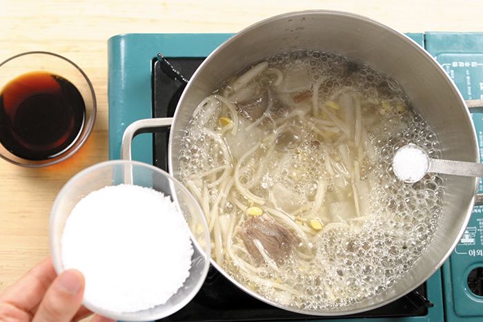 Pour the broth into the pot and bring it to a boil. Add the seasoned beef, radishes, bracken, bellflower roots and bean sprouts. Season with the clear soy sauce and add salt to taste. Do not boil the bean sprouts too long or they may become tough.