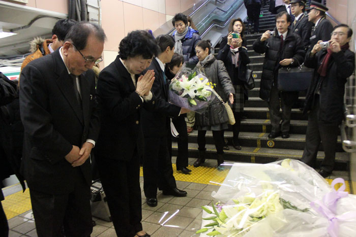 The parents of Lee Soo-Hyun (left) pay silent tribute, marking the 13th anniversary of the death of their son after laying a wreath at Shin-Ōkubo Station in Tokyo in January 2014. Their son lost his life while trying to save a man who fell from the platform.
