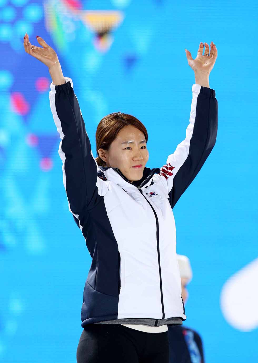 Speed skater Lee Sang-hwa smiles as she raises her hands during the award ceremony at the Sochi Medals Plaza, near the Coastal Cluster of Olympic venues, in Sochi on February 12. (Photo courtesy of the Korean Olympic Committee)