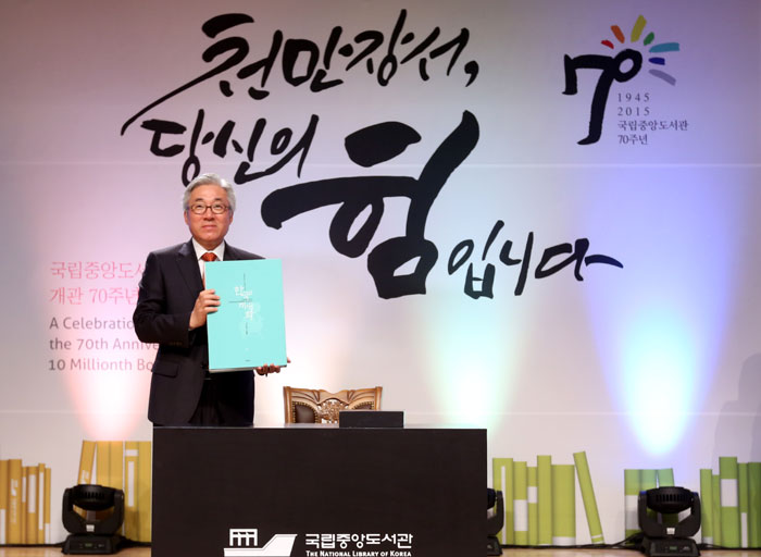 Minister of Culture, Sports and Tourism Kim Jongdeok presents the National Library of Korea with its 10 millionth book after signing an inscription in it commemorating the ceremony.