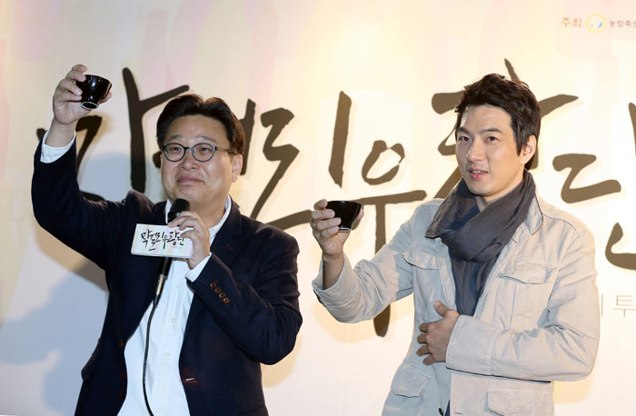 Professor Seo Kyoung-duk (left) and actor Song Il-gook raise their cups of <i>makgeolli</i> and offer up a toast. (photo: Jeon Han) 