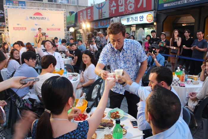 Comedian Jeong Jun-ha gives a toast of makgeolli to guests. (photo: Ygeneration) 
