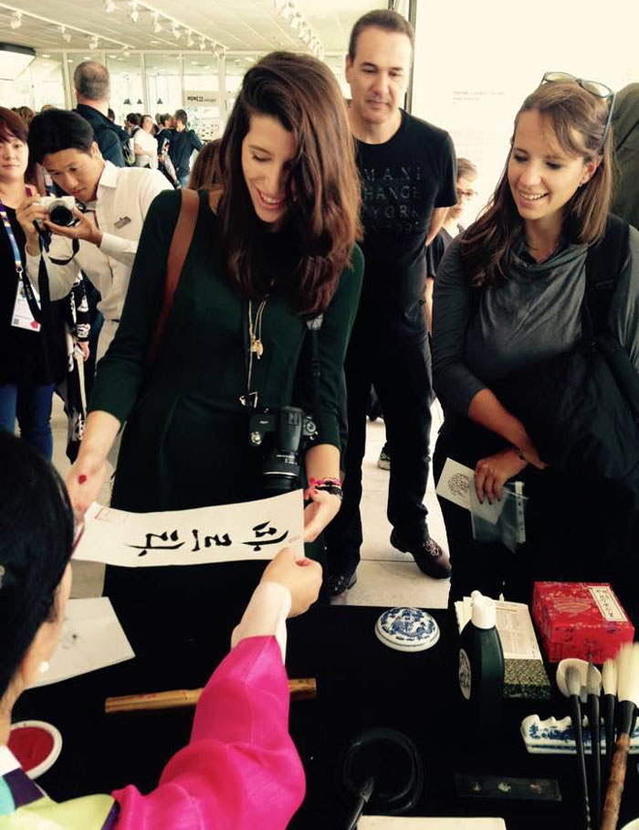 The Korea Pavilion hosts a calligraphy exhibition where visitors can get their names written in Hangeul on traditional paper.