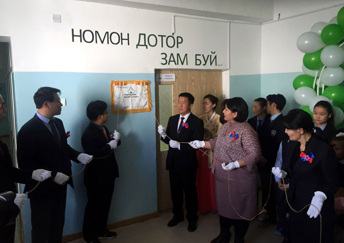 Representatives from education authorities in Dornogobi Province, as well as the school principal and teachers, hang a signboard to mark the opening of the Thank You Small Libraries book center at Secondary School No.5 in Sainshand, Dornogobi Province, on Oct. 28.