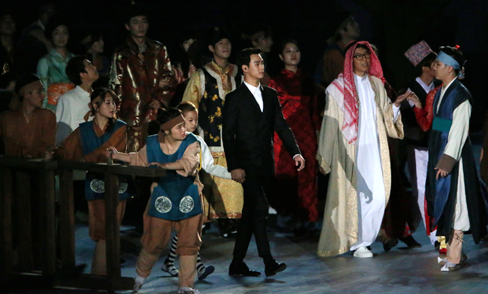 A young performer (top) rolls a hoop in the hope of unifying all Asian countries and mankind as a whole, during the opening ceremony of the Incheon Asian Games 2014 on September 19. Actor Kim Soo-hyun (bottom, center) appears on stage, holding her hand. 