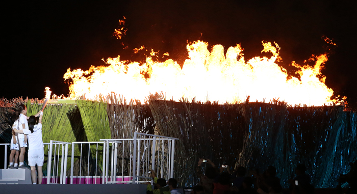 Actress Lee Young-ae, the final bearer of the Incheon Asian Games torch, lights the cauldron together with two young athletes. 