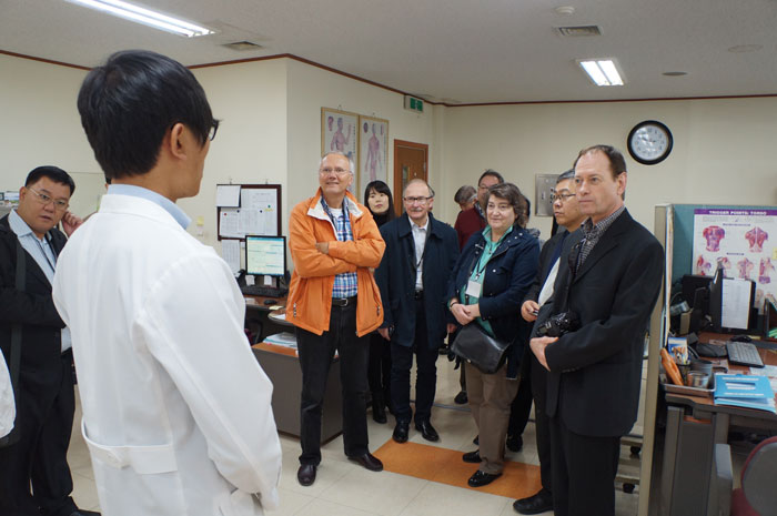 Workshop participants talk with a staff member at an Oriental medicine hospital in Korea.