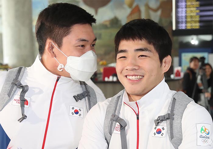 South Korean judokas Lee Seung-su (L) and An Chang-rim smile as they talk at Santos Dumont Airport in Rio de Janeiro on Aug. 3, 2016. (Yonhap)