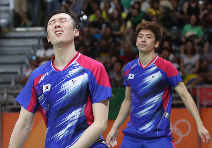 South Korean men's badminton doubles players Yoo Yeon-seong (L) and Lee Yong-dae react to their quarterfinals loss to Goh V Shem and Tan Wee Kiong of Malaysia at the Rio de Janeiro Olympics on Aug. 15, 2016. (Yonhap)