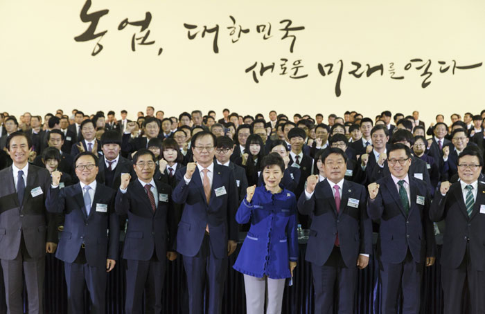President Park Geun-hye (center) poses for a photo with farmers and staff at an agricultural produce logistics center, part of the National Agricultural Cooperative Federation, in Anseong.