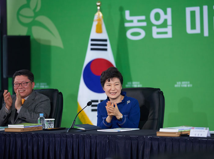 President Park Geun-hye (right) applauds after watching a promotional video on the future of the agriculture industry at a farming logistics center of the National Agricultural Cooperative Federation in Anseong, Gyeonggi-do Province, on November 19.