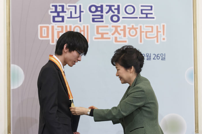 President Park Geun-hye (right) confers a medal on a member of Korea's international science Olympiads team at Cheong Wa Dae.
