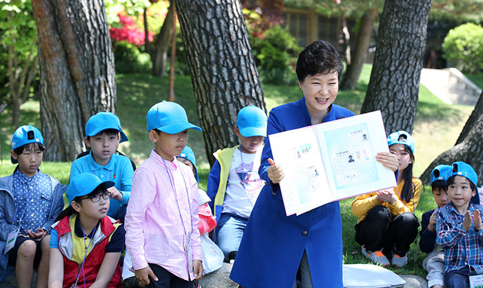 President Park Geun-hye smiles as she opens an album that the children presented to her on May 5.