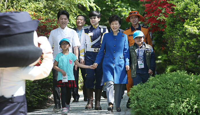 President Park Geun-hye enters the Nokjiwon Garden at Cheong Wa Dae on May 5 along with children and the police officers, firefighters and chefs who were acting as their one-day mentors.
