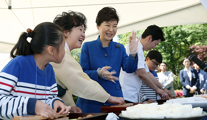 President Park Geun-hye holds up a sweet she made at the chef's career booth on May 5.