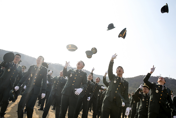 Newly commissioned officers celebrate, throwing their hats into the air, after a joint commissioning ceremony on March 6. (photo: Cheong Wa Dae)