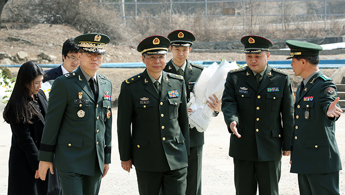 The defense attaché at the Chinese embassy in Seoul, Du Nong Yi (center), and the Korean army's Brigadier General Moon Sang Gyun (left, front row) enter the venue for the coffin rites on March 16.