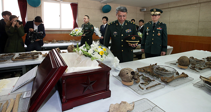 Defense attaché at the Chinese embassy in Seoul Du Nong Yi (second from right) pays his respects to the remains of Chinese soldiers, during the coffin rites ceremony at the 25th division of the Korean army in Paju City on March 16. The Korean army's Brigadier General Moon Sang Gyun stands at his side. 