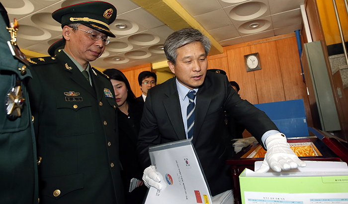 A Korean military official explains to Defense Attaché Du Nong Yi how the remains of Chinese soldiers will be returned to China.