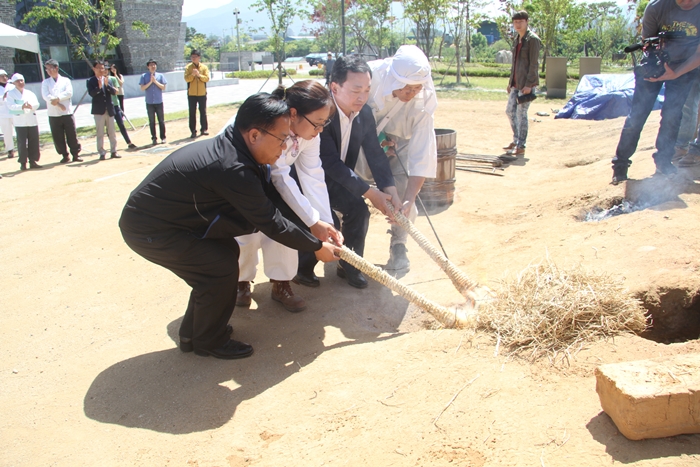 Officials light the bloomery’s fuel on May 27.