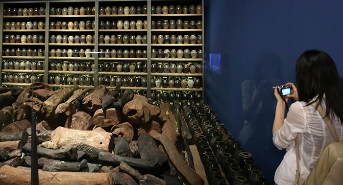 Museum-goers look at pieces of red sandalwood and works of porcelain, all part of the items loaded onboard the Sinan ship.