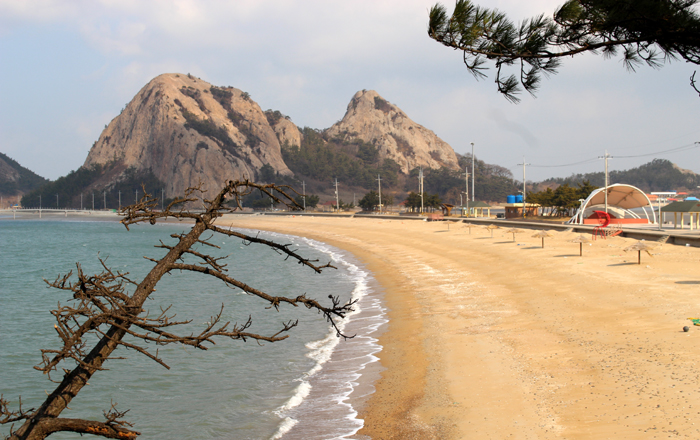 Next to Mangjubong Peak unfolds Myeongsasimni Beach, a heart-shape sliver of sandy shoreline. 