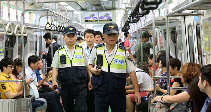Chief Inspector Kim Yeong-chae (right) and Kim Sun-cheol of Seoul's subway police unit patrol a car on line No. 2, along with other police officers.