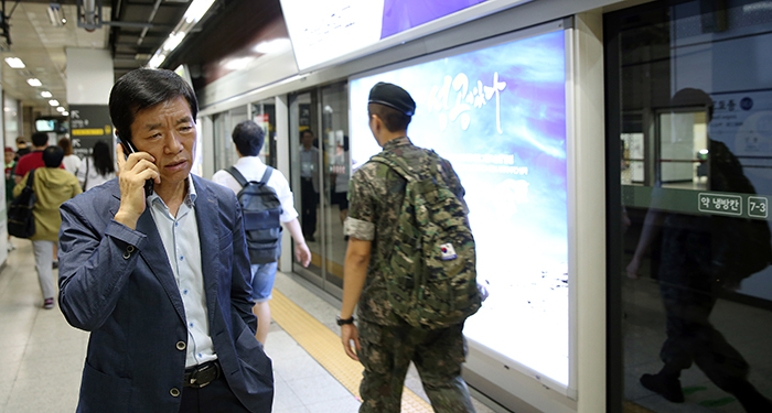 Chief Investigator Park Seong-dong talks on the phone with his fellow officers at the Jongno 3-ga Station. He said that uniformed policemen go out on formal patrol while plainclothes cops conduct other observation duties.