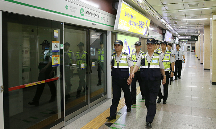 Chief Inspector Kim Yeong-chae (right) and Kim Sun-cheol of Seoul's subway police unit head out on patrol around the Dongdaemun History & Culture Park Station. 