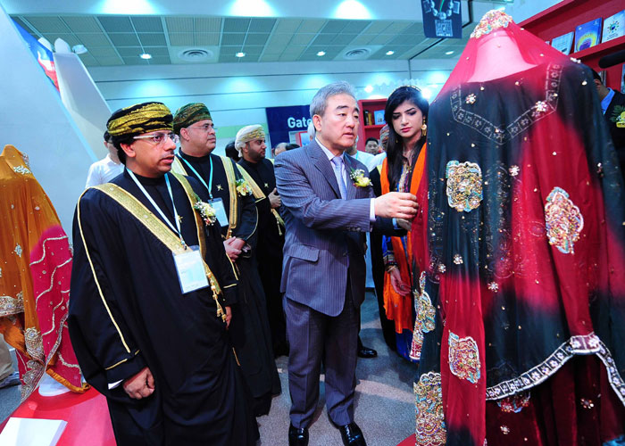 Minister of Culture, Sports & Tourism Yoo Jinryong (center) and Omani Minister of Information Dr. Abdulmunim bin Mansour Al Hasani look closely at a traditional dress on display at the Oman booth of the Seoul International Book Fair 2014, on June 18 at COEX in southern Seoul. (photos: Ministry of Culture, Sports and Tourism)