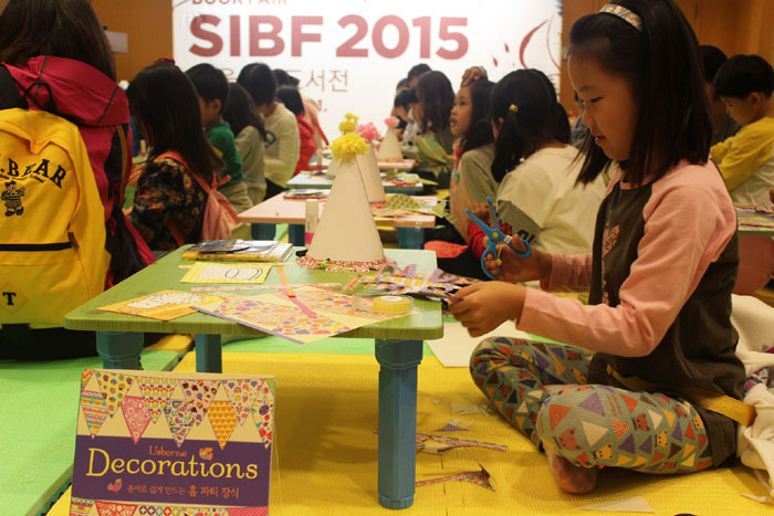 Children make paper decorations in the 'book art handicraft workshop' at the Seoul International Book Fair 2015.