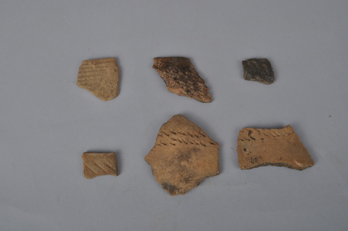  (Top) A stone-lined chamber from the Three Kingdoms Period. (Bottom) Broken pieces of earthenware from the Neolithic era are found underneath the tomb. (photos courtesy of the CHA) 