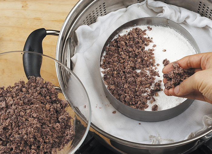 Put water in the steamer and heat it. When it begins to boil, place a wet cotton cloth and place a cake mold on top of the cloth. Put the mashed red bean paste on the bottom and then place rice powder on top of it. Make sure the surface is even and put the remaining red beans on top. Boil the rice cake about 15 minutes. You can also change the amount of water, depending on the moistness of the rice powder.