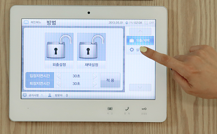 A touch-screen wall pad in the living room allows residents to switch on a surveillance system when leaving their home, calculate their electricity usage and make calls to other residents in the same complex.