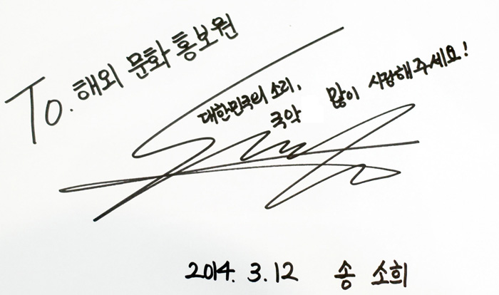 Gugak singer Song So-hee signs an autograph for Korean.net readers. It says, “Please give your support to gugak, the sound of Korea!” 