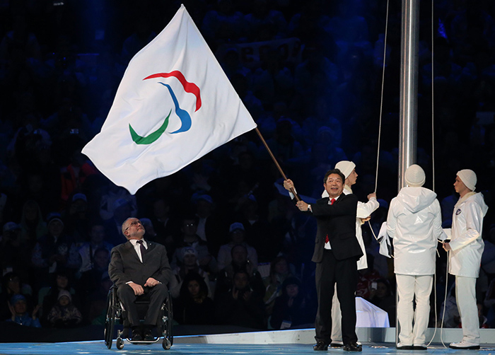Lee Seok-rae (right), mayor of Pyeongchang, waves the International Paralympic flag upon receiving it from the International Paralympic Committee President Sir Philip Craven (left). (photo: Yonhap News)
