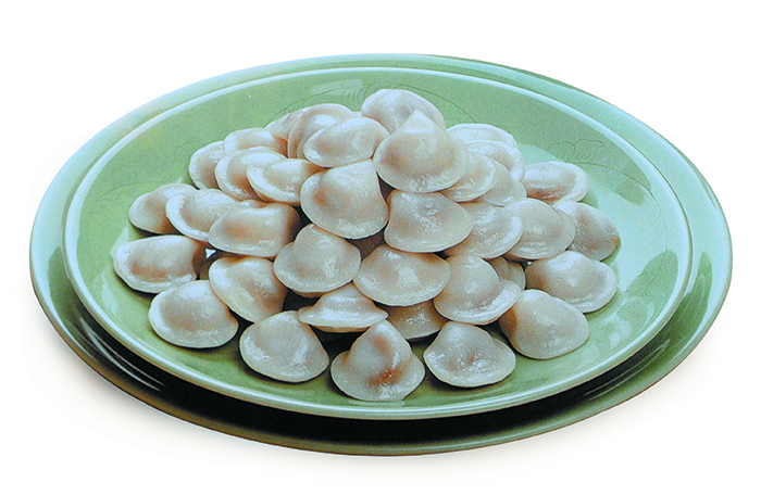<i>Jogae songpyeon</i> or seashell <i>songpyeon</i> got its name for its seashell-shaped appearance. It is made from non-glutinous rice powder with a filling made from sesame seeds, sugar and soy sauce.