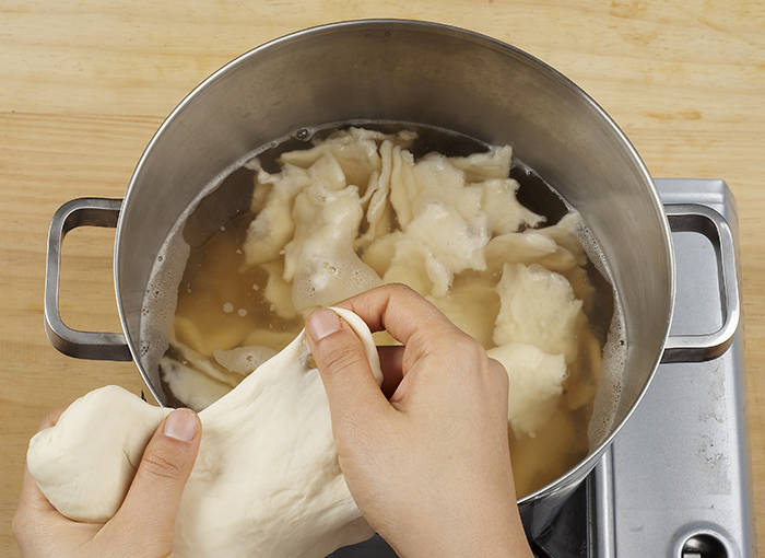 Boil the anchovy stock for 8 minutes and add the potato pieces. Boil it over high for 3 minutes. Make the dough pieces by pulling them from the batter into thin, bite-sized pieces. Boil it all for 5 minutes.