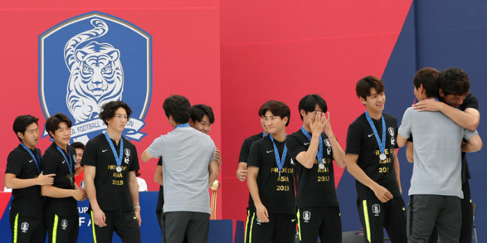 U-20 head coach Chung Jung-yong and his staff on June 17 hug their players at the   end of their welcoming ceremony at Seoul Plaza.