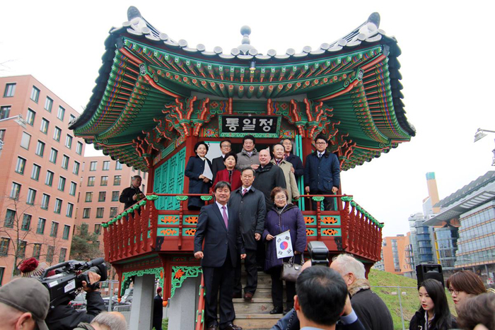 25일 베를린 포츠담 광장에서 열린 '통일정' 준공식에서 방문객들이 통일정 앞에서 사진을 찍고 있다.