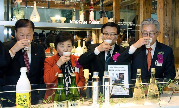 Minister of Culture, Sports and Tourism Kim Jongdeok (right) and Minister of Agriculture, Food & Rural Affairs Lee Dong-phil (second from right) sample some traditional alcohols at the Sool Gallery on February 11. 