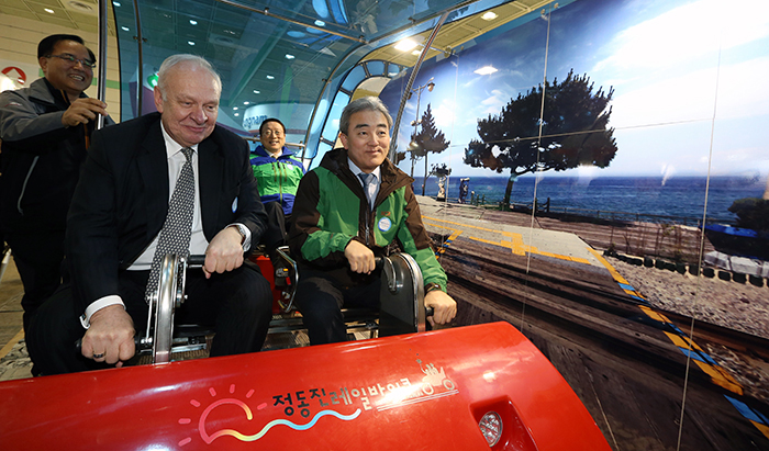 Minister of Culture, Sports and Tourism Yoo Jinryong (right) tries out a <i>jeongdongjin</i> rail bike with Russian Ambassador to Korea Konstantin Vnukov at the 2014 Korea Travel Expo held at COEX in Seoul on February 27. (photo: Jeon Han)