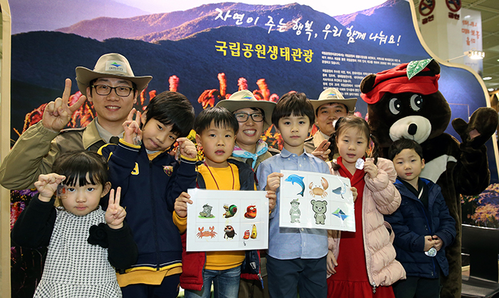 Tour guides from the Korea National Park pose with young travelers. The kids show off the animal-shaped key chains and necklaces they made. (photo: Jeon Han) 