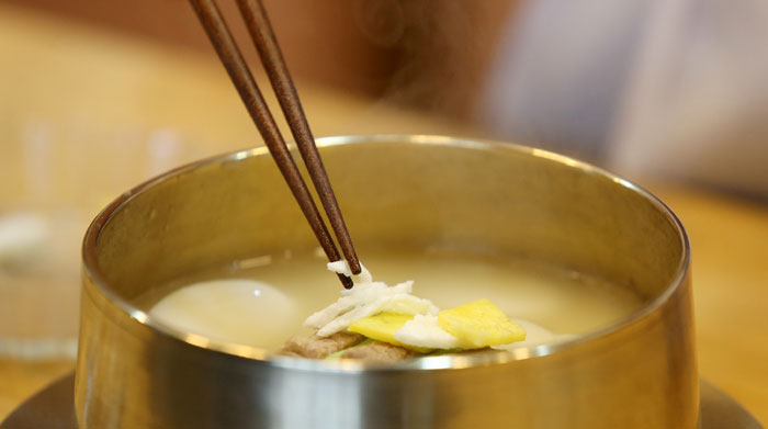 When the soup is done, serve it in a large bowl and place some beef bits, egg white slices, egg yolk slices and some red pepper on top as a garnish. You can also add some fried beef for decoration, too.